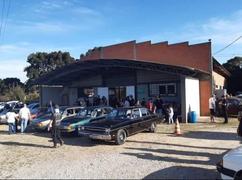 eine Gruppe von Autos, die außerhalb eines Gebäudes geparkt werden in der Unterkunft Espaço Festas Eventos Corporativos in Balsa Nova