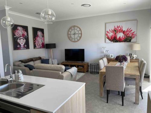 een keuken en een woonkamer met een tafel en een woonkamer bij Hamptons House Mudgee -Lux Stays in Mudgee