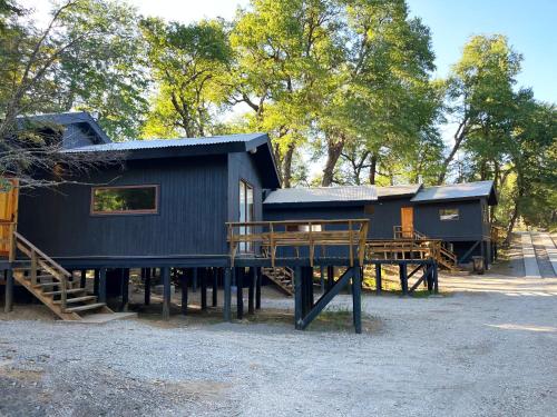 a black house with a porch and a playground at Cabañas Kalinaw in Las Trancas