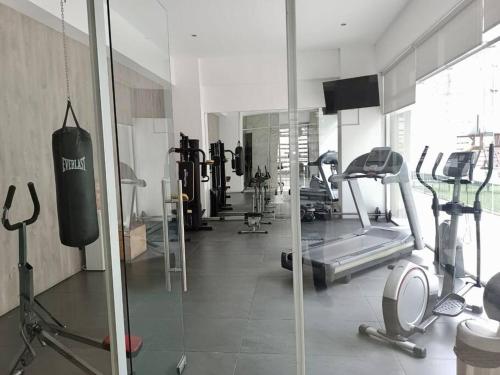 una palestra con diversi tapis roulant e macchine in una stanza di La mejor opción Departamento Senza 3 a El Gallinero