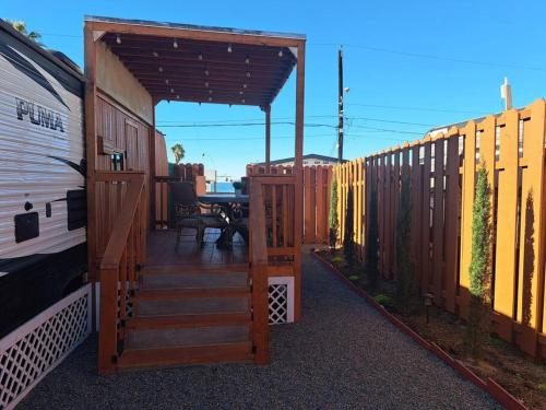 a wooden deck with a table and a fence at Sunset Trailer Park RV #1 in El Suazal
