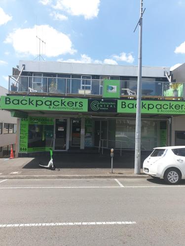 a person walking a dog in front of a building at Backpackers Central Hamilton in Hamilton