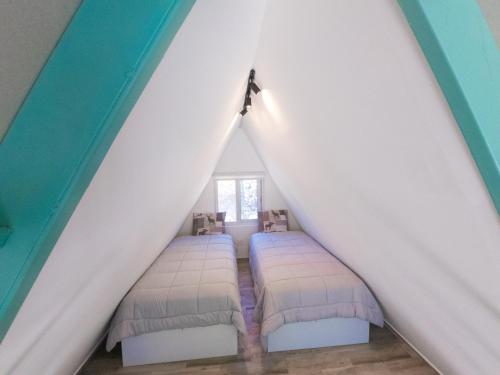 a room with three beds in a attic at Cabaña puente Wilson in Alto Boquete