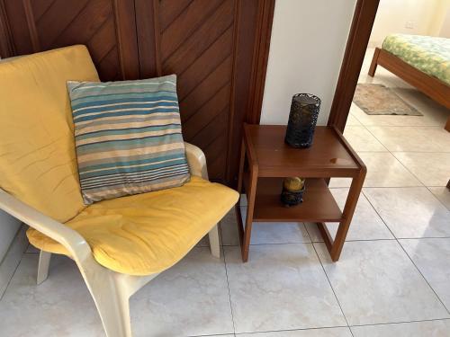a yellow chair with a pillow next to a side table at Quien lo vive es quien lo goza in Barranquilla