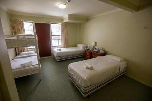 um quarto com 2 camas e um beliche em Lucy Lodge em Charlotte Pass