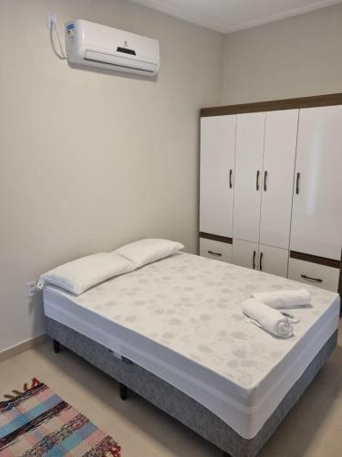 a bedroom with a bed and a air conditioner at Villa do Aconchego apartamento super novo in Búzios