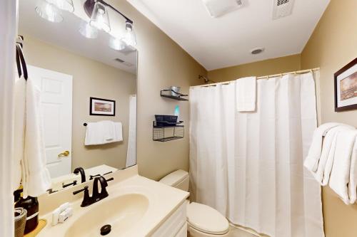 a bathroom with a sink and a toilet and a shower at The Carolina Shell in Ocean Isle Beach