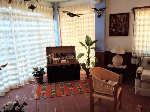 ein Wohnzimmer mit einem Sofa, einem Tisch und einem Stuhl in der Unterkunft Oaxaca Deleite in Oaxaca de Juárez