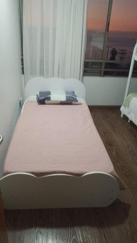 a bed sitting in a room with a window at VSM propiedades in Iquique