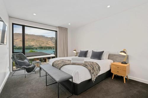 a bedroom with a large bed and a large window at Lakefront Premier Studio in Wanaka