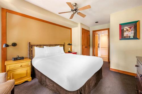 a large white bed in a room with a ceiling fan at Hilton Grand Vacations Club Whistler in Whistler