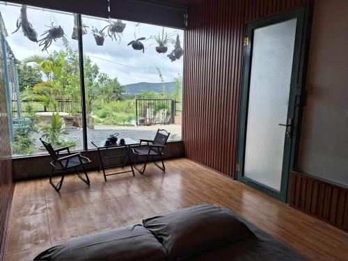 a living room with chairs and a large window at Windy Home in Ấp Man Ling