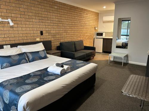 een slaapkamer met een bed met een knuffeldier erop bij Motel Woongarra in Rutherglen