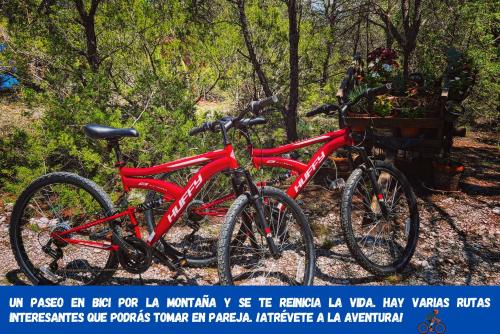 two red bikes parked next to each other at Pequeña cabaña mágica con chimenea interior in Arteaga