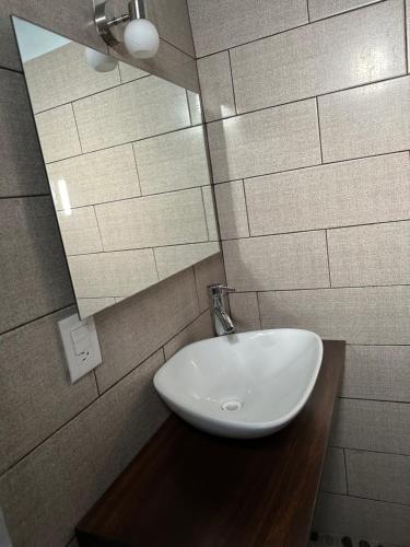 a bathroom with a white sink and a mirror at Hotel Cabañas Pepe in Puerto Escondido
