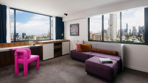 salon z fioletową kanapą i różowym krzesłem w obiekcie Hotel Indigo Sydney Potts Point, an IHG Hotel w mieście Sydney
