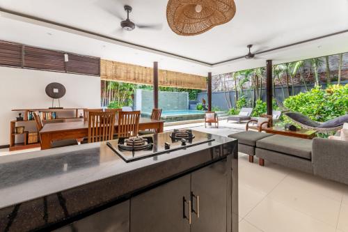 an open kitchen and living room with a couch at Villa Coco Bali in Seminyak