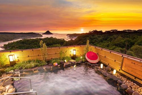 a hot tub with a view of the sunset at Ooedo Onsen Monogatari Amakusa Hotel Kameya in Kami Amakusa