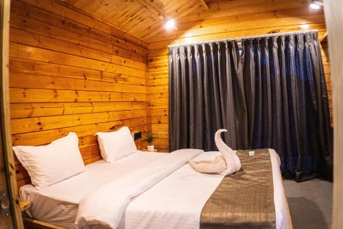 a bedroom with a bed with a swan on it at Tranquill Riverside Luxury Cottages With Bathtub, Candolim in Candolim