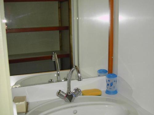 un lavandino in bagno con specchio e vasca di Chalet familial avec piscine, animaux acceptés, draps inclus, proche de Montluçon et Gannat - FR-1-489-323 a Échassières