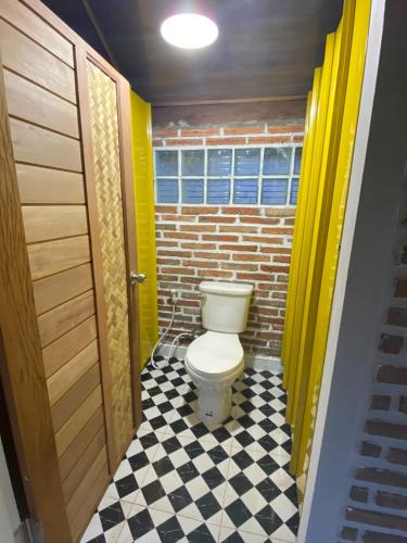 a bathroom with a toilet and a checkered floor at บ้านอัญชัน 