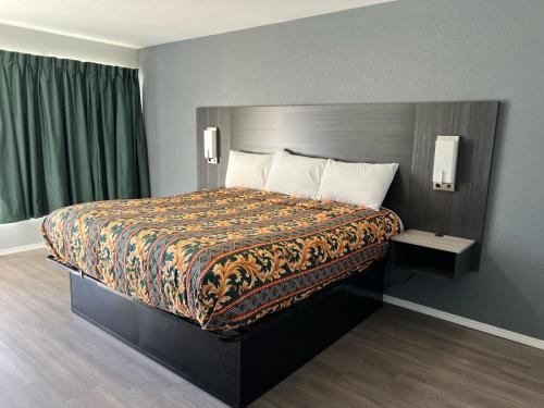 1 dormitorio con 1 cama grande con una manta colorida en Pioneer INN, en Arkadelphia