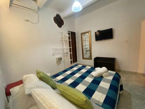 a bedroom with a blue and white checkered bed at Patio de Getsemani in Cartagena de Indias