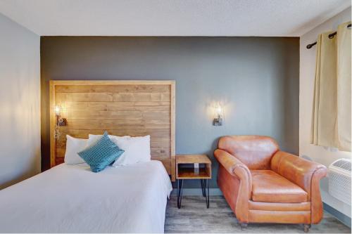 a hotel room with a bed and a chair at The Infusion Beach Club in Palm Springs