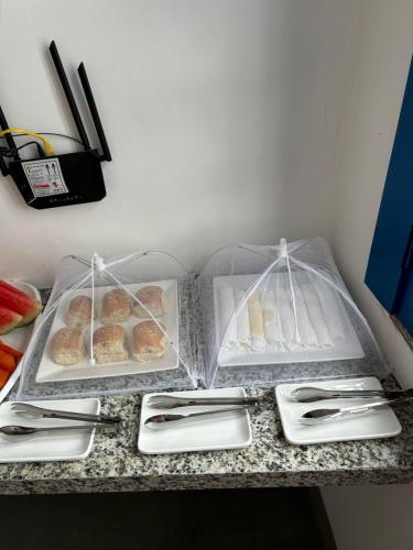 Zwei Plastikbehälter mit Gebäck stehen auf einer Theke. in der Unterkunft Casa Grécia Pousada in Santo Amaro
