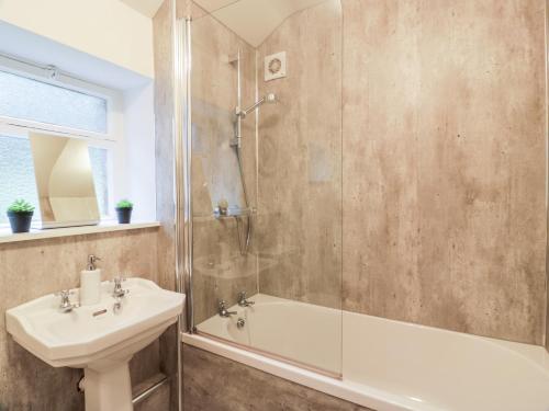 a bathroom with a shower and a sink and a tub at Gate Lodge - Threave Estate in Castle Douglas