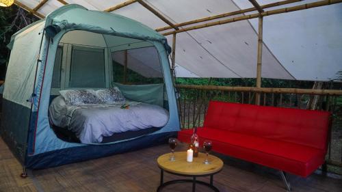 a tent with a bed and a table in it at Glamping Salento y Posada Villa Alegría in Salento