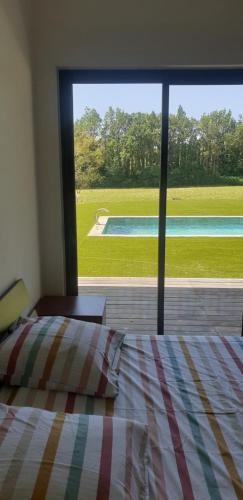 een slaapkamer met een bed en uitzicht op een zwembad bij La lavandière in Fox-Amphoux