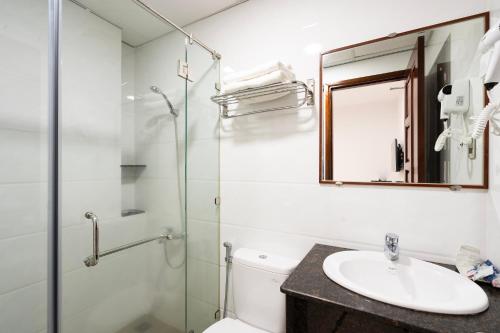 y baño con ducha acristalada y lavamanos. en HOÀNG HOTEL, en Ho Chi Minh