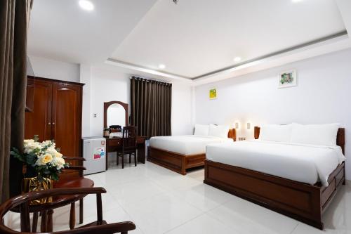 Habitación de hotel con 2 camas y escritorio en HOÀNG HOTEL, en Ho Chi Minh