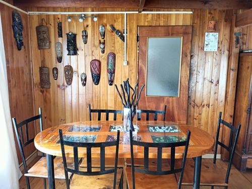 uma sala de jantar em madeira com uma mesa e cadeiras em madeira em Casa en sector isla teja em Valdivia