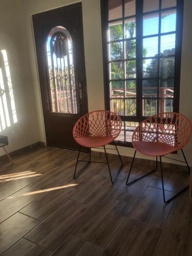 dos sillas sentadas frente a una puerta en Noelle’s House - Alto Boquete, a natural place to enjoy., en Alto Boquete
