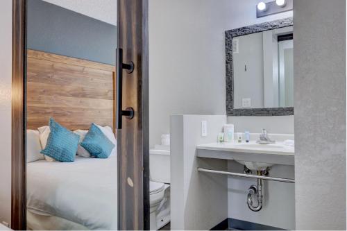 a bathroom with a bed and a sink and a mirror at The Infusion Beach Club in Palm Springs