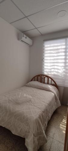 um quarto com uma cama num quarto com uma janela em Casa Salinas em Salinas