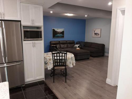 ein Wohnzimmer mit einem Sofa und einem Tisch sowie eine Küche in der Unterkunft King guest apartment in Ottawa