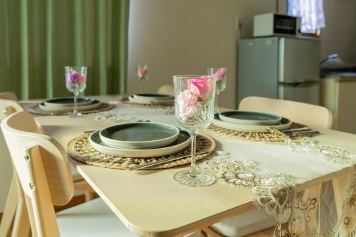 a dining room table with plates and glasses on it at 302号室貸切 京成佐倉駅徒歩3分 電車成田空港20分 京成上野直結 厨房 風呂 畳 in Sakura