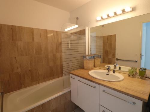 une salle de bain avec un lavabo, une baignoire et un miroir dans l'établissement 3 pièces climatisé avec terrasse à Sète - FR-1-472A-206, à Sète