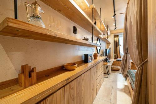 a kitchen with a long counter with wooden cabinets at Shanghai Hills&Well-time B&B Xuhui in Shanghai