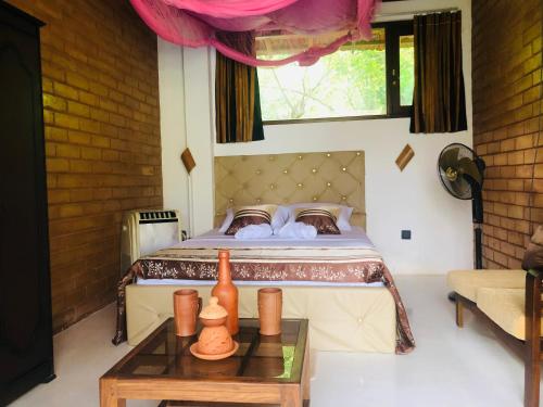 a bedroom with a bed with a table in front of it at Outskirts Of Heaven in Kamburugamuwa