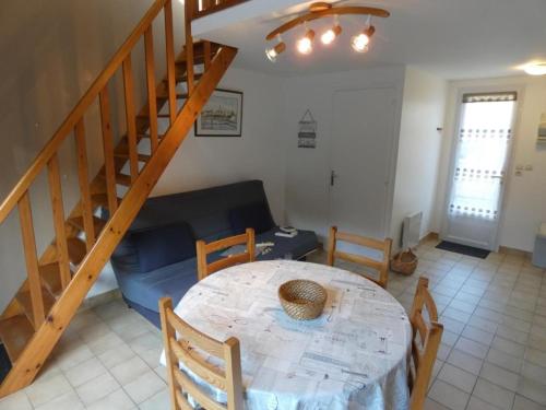 un salon avec une table et un escalier dans l'établissement Maison avec Terrasse Proche Plage - Notre-Dame-de-Monts, 4 Pers. - FR-1-540-225, à Notre-Dame-de-Monts