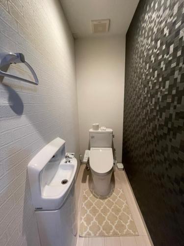 ein Badezimmer mit einem weißen WC und einem Waschbecken in der Unterkunft 新潟県小千谷市 平成イン 
