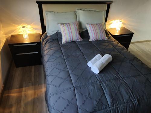 a bed with two pillows and towels on it at Torre del Limay in Neuquén