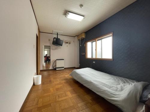 a bedroom with a bed and a blue wall at 小千谷市 平成イン 