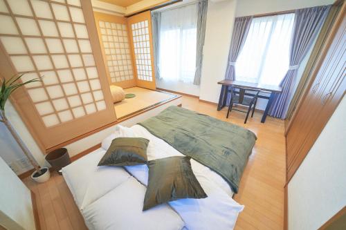 a room with a bed with two pillows on it at FINOA Ikebukuro Sky Terrace Suite in Tokyo