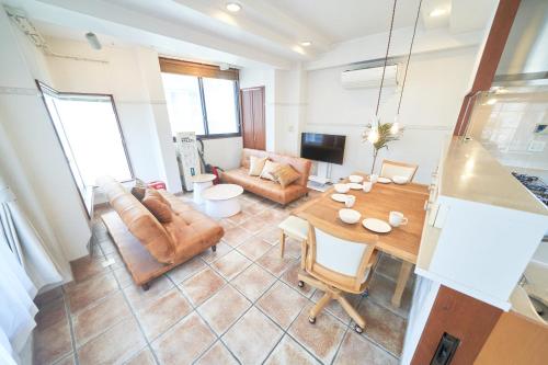 a living room with a table and a couch at FINOA Ikebukuro Sky Terrace Suite in Tokyo