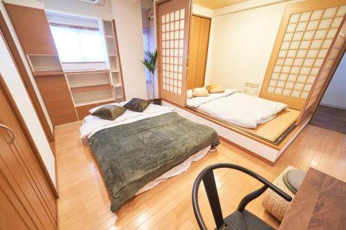 two beds in a room with a mirror at FINOA Ikebukuro Sky Terrace Suite in Tokyo